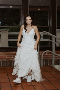 bride shows off sneakers in wedding dress