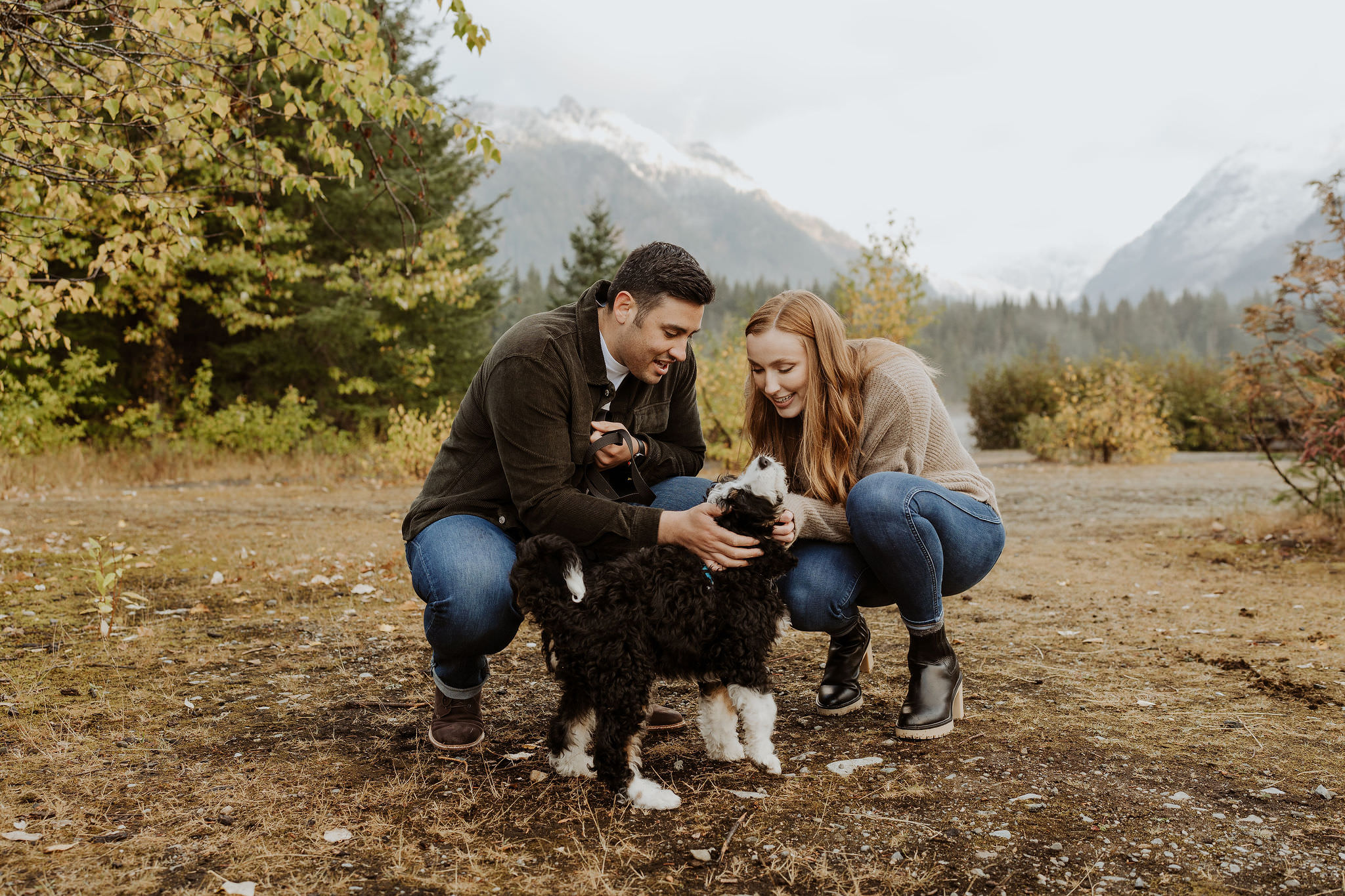 couple with their puppy in front of Gold Creek Pond
