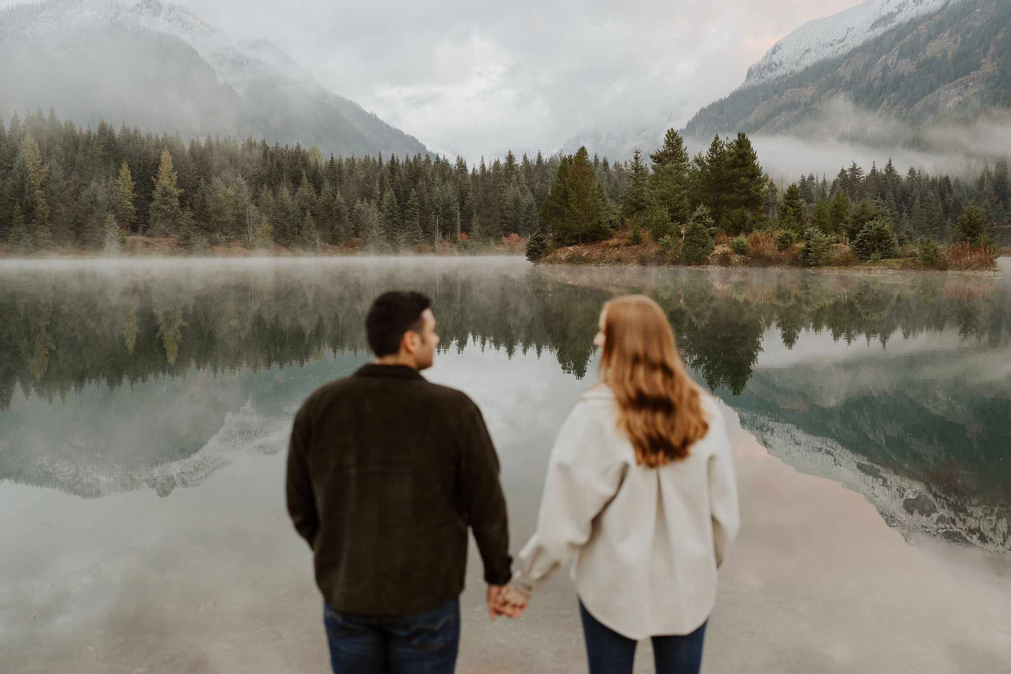 couple holding hands facing the water at Gold Creek Pond